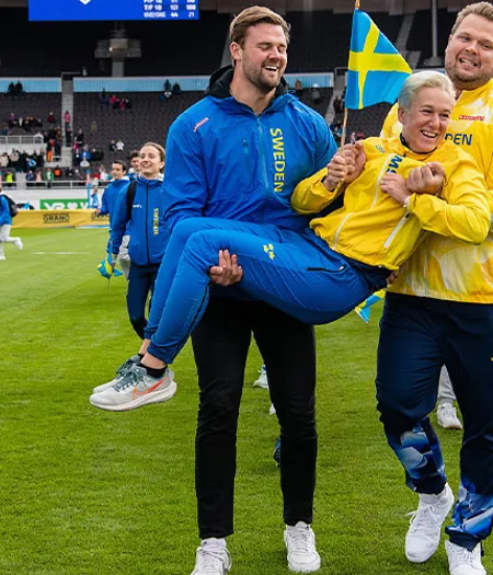 Simon Pettersson och Daniel Ståhl på väg att kasta förbundskapten Kajsa Bergqvist i vattengraven.
